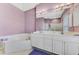 Bright primary bathroom with large mirrors, double sinks, and a large soaking tub at 52 Marker Rd, Rotonda West, FL 33947