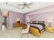 Main bedroom with carpet floor, tray ceilings, a ceiling fan, and light wood furniture at 52 Marker Rd, Rotonda West, FL 33947