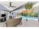 Relaxing pool area inside a screen enclosure featuring a ceiling fan and lounge area at 52 Marker Rd, Rotonda West, FL 33947