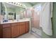 Bathroom with shower, vanity, and wood cabinets at 5560 Club View Ln, North Port, FL 34287