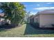 House side view, showing tan walls, red tile roof, and lush landscaping at 5560 Club View Ln, North Port, FL 34287