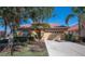 House front view with tan walls, red tile roof, and two-car garage at 5560 Club View Ln, North Port, FL 34287