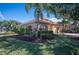 House exterior showcasing tan walls, red tile roof, and manicured landscaping at 5560 Club View Ln, North Port, FL 34287