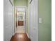 Bright hallway with wood flooring and access to bathroom and closets at 5560 Club View Ln, North Port, FL 34287