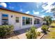 Back exterior view shows a sliding glass door leading to a patio, surrounded by lush landscaping at 615 Apple Ln, Englewood, FL 34223