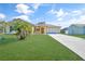 House exterior featuring a yellow single-story home with a two-car garage and manicured lawn at 6176 Catalan St, Englewood, FL 34224