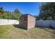 Brown storage shed in backyard with white vinyl fence at 6176 Catalan St, Englewood, FL 34224