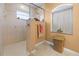 Walk-in shower with beige tile and a window in a beige bathroom at 62 Marker Rd, Rotonda West, FL 33947