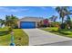 Coral house with blue garage door and well-manicured lawn at 62 Marker Rd, Rotonda West, FL 33947