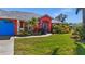 Front entrance of coral house with blue door and walkway at 62 Marker Rd, Rotonda West, FL 33947