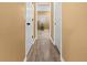 Long hallway with light brown laminate flooring and doors to other rooms at 62 Marker Rd, Rotonda West, FL 33947