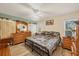 Main bedroom with king-size bed, wood dresser, and ceiling fan at 6699 San Casa Dr # T1, Englewood, FL 34224