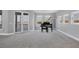 Open living space with a grand piano and access to balcony at 7180 Brittany Cir, Englewood, FL 34224