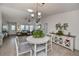 Bright dining area with white table and chairs, adjacent to living room at 7336 Brookhaven Ter, Englewood, FL 34224