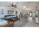 Open concept living and dining area with brown couches, a dining table, and wood flooring at 7336 Brookhaven Ter, Englewood, FL 34224