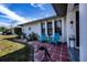 Charming patio with teal chairs, decorative accents, and red tile flooring at 7336 Brookhaven Ter, Englewood, FL 34224