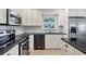 Modern kitchen with white cabinets and black countertops at 7398 Spinnaker Blvd, Englewood, FL 34224