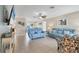 Bright living room featuring tile floors, comfy sofas, and a large TV at 7398 Spinnaker Blvd, Englewood, FL 34224