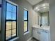 Bright bathroom featuring a white vanity, quartz countertop, and large windows at 7410 Grand Concourse St, Englewood, FL 34224