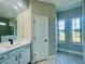 Modern bathroom with white vanity, quartz countertop, and large windows at 7410 Grand Concourse St, Englewood, FL 34224