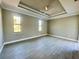 Large bedroom with tray ceiling, two windows and ceiling fan at 7410 Grand Concourse St, Englewood, FL 34224