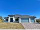 Single-story home with three-car garage and paver driveway at 7410 Grand Concourse St, Englewood, FL 34224