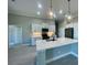 Modern kitchen with white cabinets, quartz countertops, and an island at 7410 Grand Concourse St, Englewood, FL 34224