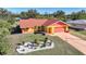 Attractive single-story home with orange and yellow exterior, landscaped yard, and driveway at 7438 Banbury Ter, Port Charlotte, FL 33981