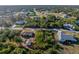 Aerial view of the property lines, home, detached garage, lush surrounding landscape, and the neighboring street at 7522 Sea Mist Dr, Port Charlotte, FL 33981