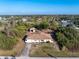 An aerial view of a single-story home surrounded by lush greenery with a detached garage and long driveway at 7522 Sea Mist Dr, Port Charlotte, FL 33981