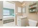 Bright bathroom features a vanity with ample storage, decorative shelving, and a view of the bedroom at 7522 Sea Mist Dr, Port Charlotte, FL 33981