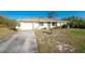 Classic single-story home features a concrete driveway, mature landscaping, and a one-car garage at 7522 Sea Mist Dr, Port Charlotte, FL 33981