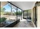 Screened porch with stone tile, offering a scenic view of a garden and outdoor seating area for relaxation at 7522 Sea Mist Dr, Port Charlotte, FL 33981