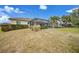 Expansive backyard featuring a screened lanai, lush shrubs, and a well-maintained lawn at 8 Broadmoor Ln, Rotonda West, FL 33947