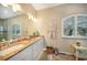 Well-lit bathroom featuring double sinks, granite countertops, vanity and an arched window for natural light at 8 Broadmoor Ln, Rotonda West, FL 33947