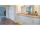 Bathroom with double vanity, granite countertop, white cabinets and modern lighting, alongside wood-look floors at 8 Broadmoor Ln, Rotonda West, FL 33947