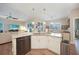 Bright kitchen island with white cabinets, granite countertops, stainless appliances and views to the living space at 8 Broadmoor Ln, Rotonda West, FL 33947