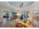 Inviting living room with comfortable seating, wood-look floors, and a tray ceiling at 8 Broadmoor Ln, Rotonda West, FL 33947