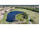 Aerial view of community with golf course, pond, and homes at 8377 Parkside Dr, Englewood, FL 34224