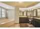 Elegant bathroom featuring a corner soaking tub and updated double vanity at 8377 Parkside Dr, Englewood, FL 34224