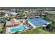 Aerial view of community pool, lounge chairs, and tennis courts at 8377 Parkside Dr, Englewood, FL 34224