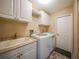 Laundry room with washer, dryer, utility sink, and extra cabinets at 8377 Parkside Dr, Englewood, FL 34224