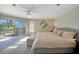 Main bedroom with king bed, wood-look floors, and sliding doors to the backyard at 8377 Parkside Dr, Englewood, FL 34224