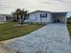 White single-wide manufactured home with carport and landscaped lawn at 8479 Tanaka Dr, Englewood, FL 34224