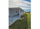 Side view of a manufactured home with covered porch and landscaping at 8479 Tanaka Dr, Englewood, FL 34224