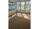 Sunroom with carpeted floor and windows overlooking the yard at 8479 Tanaka Dr, Englewood, FL 34224