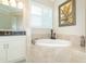 Bathroom with soaking tub, double vanity, and window at 8960 Scallop Way, Placida, FL 33946