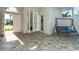 Front entry with tiled flooring and a porch swing at 8960 Scallop Way, Placida, FL 33946