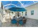 Outdoor dining area on a covered patio with blue umbrellas at 8960 Scallop Way, Placida, FL 33946