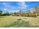 Expansive backyard featuring a well-manicured lawn and tropical landscaping at 910 Park Place Dr, Englewood, FL 34223